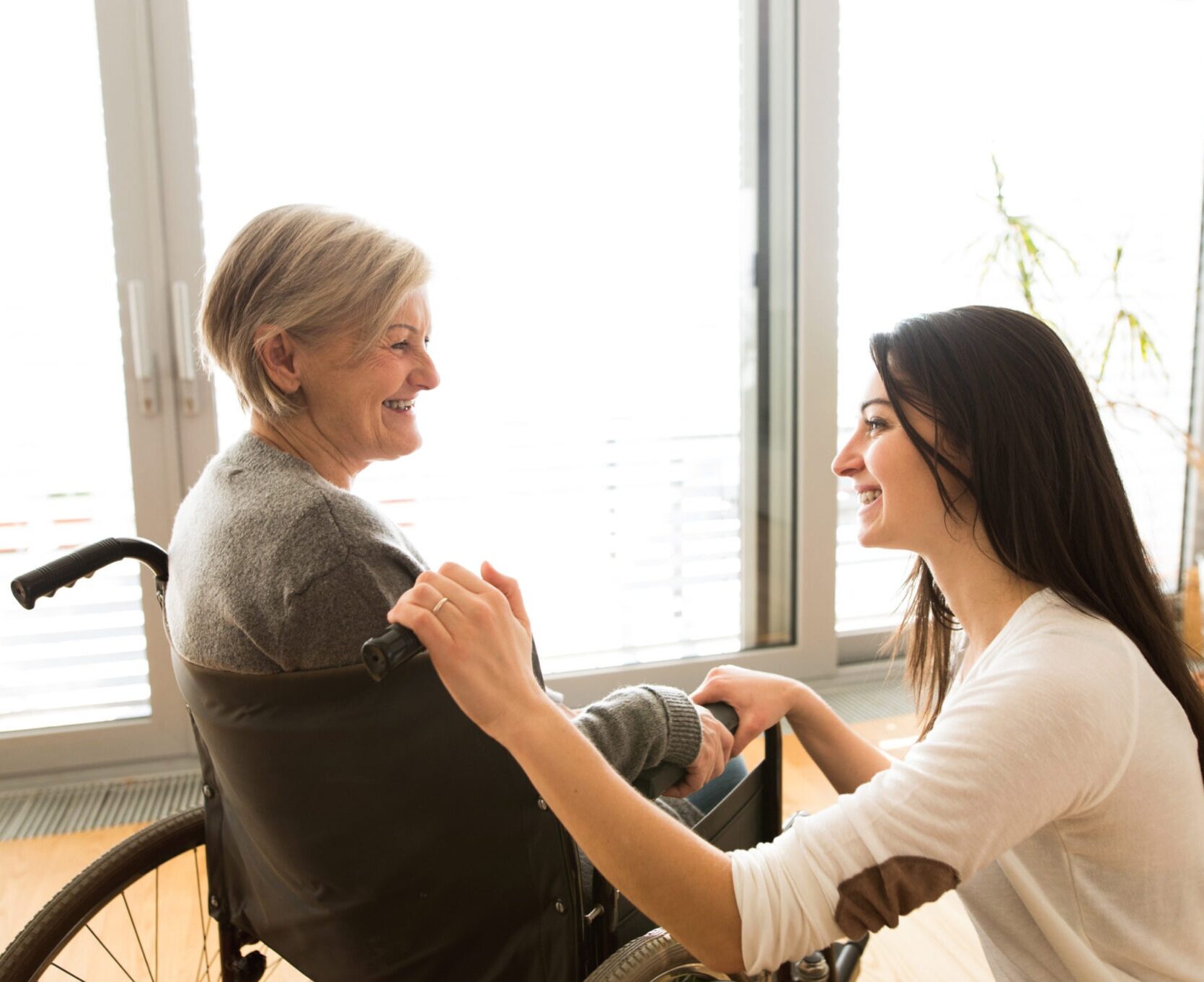 imageye___ _imgi_46_graphicstock disabled senior woman in wheelchair at home in her living room with her young daughter caring for her_SdM7iNOLzZ scaled 1 2048x1363 1 e1778518771954
